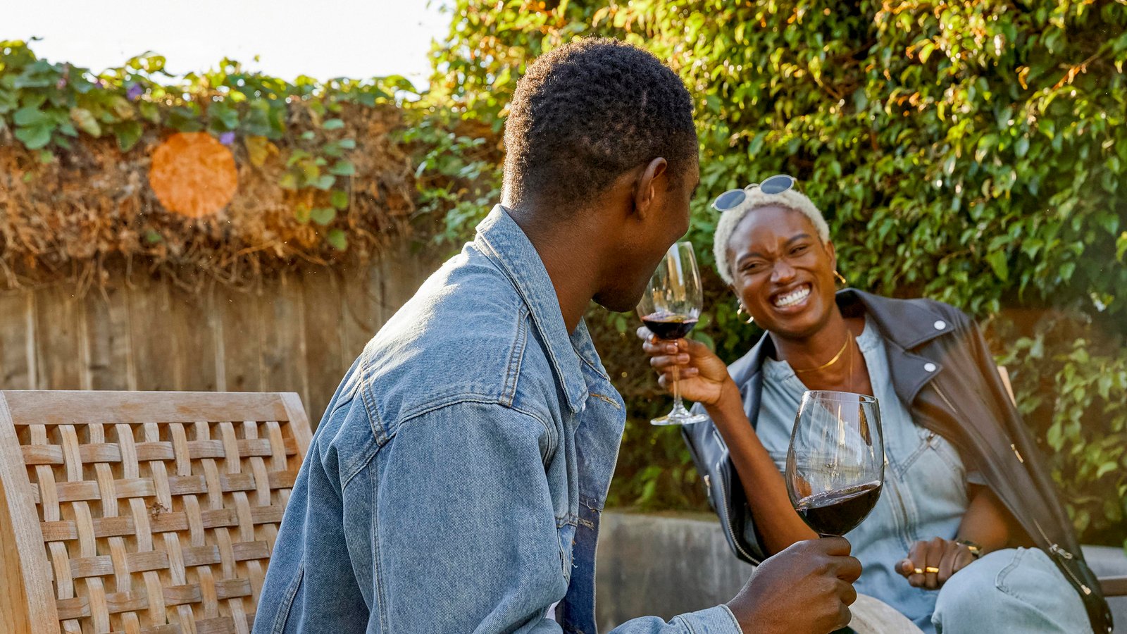 A couple laughing together over wine in a garden